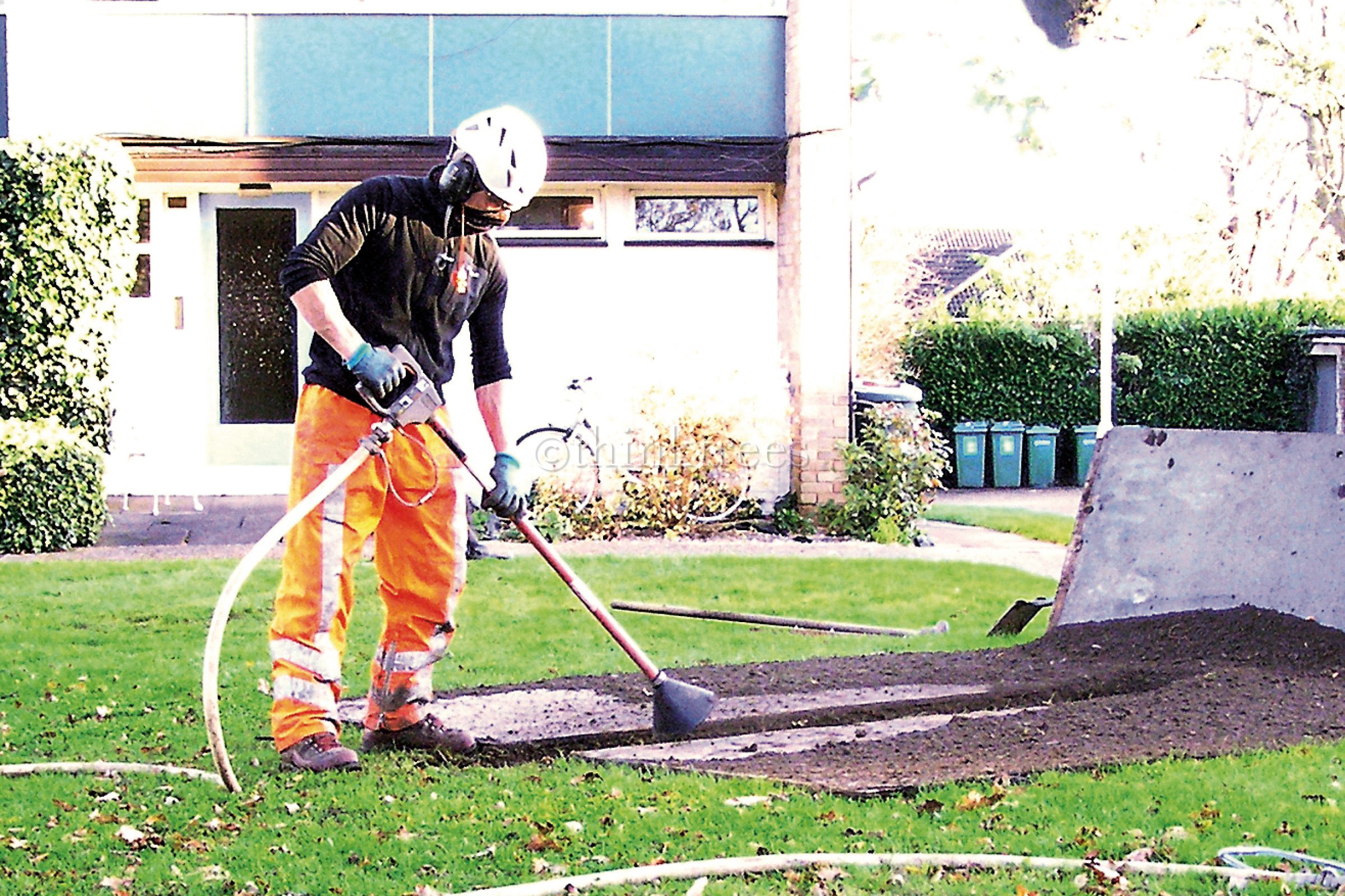 Arborist using a soilpick to excavate a radial trench